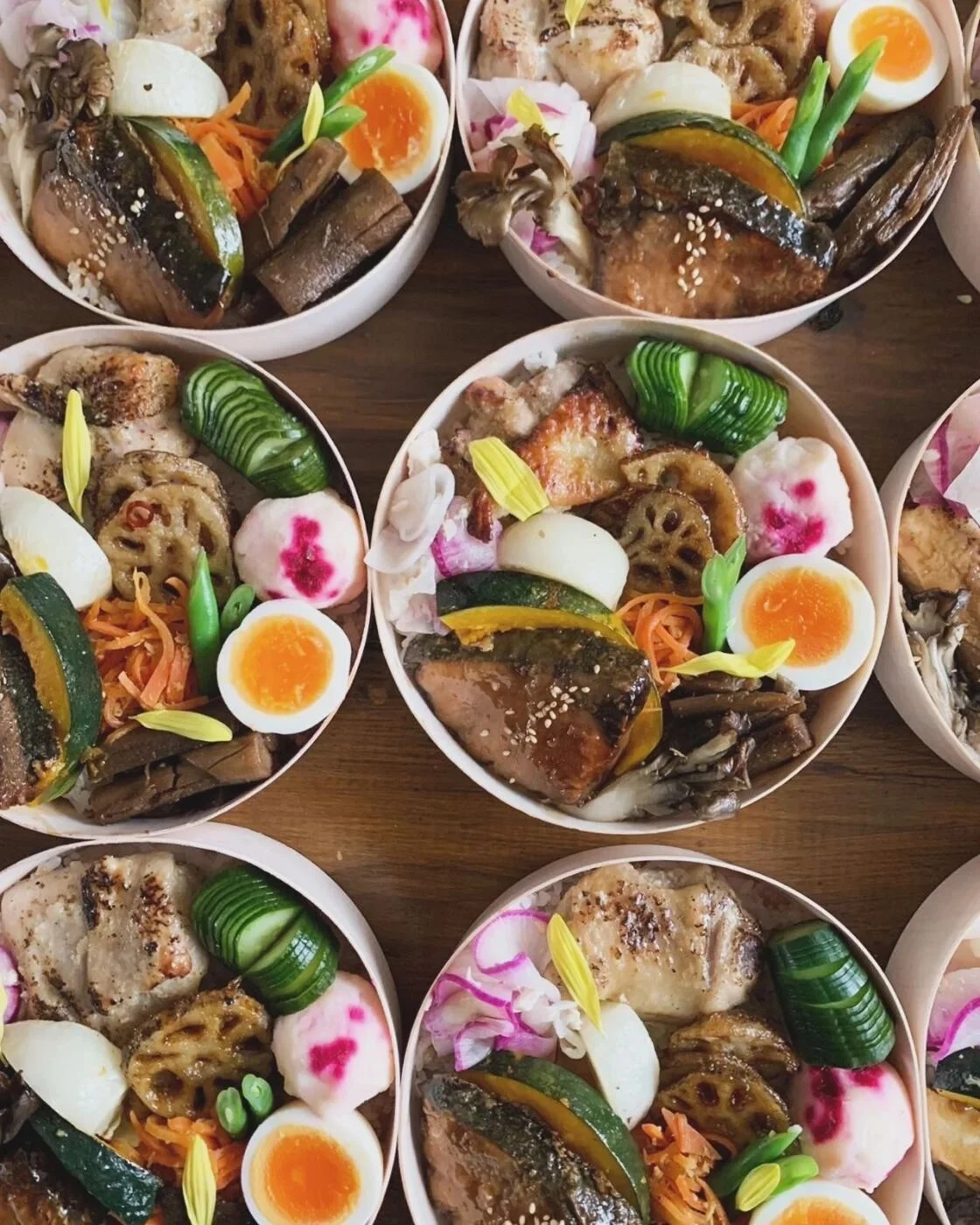 Round bento boxes with rice, vegetables and a selection of dishes