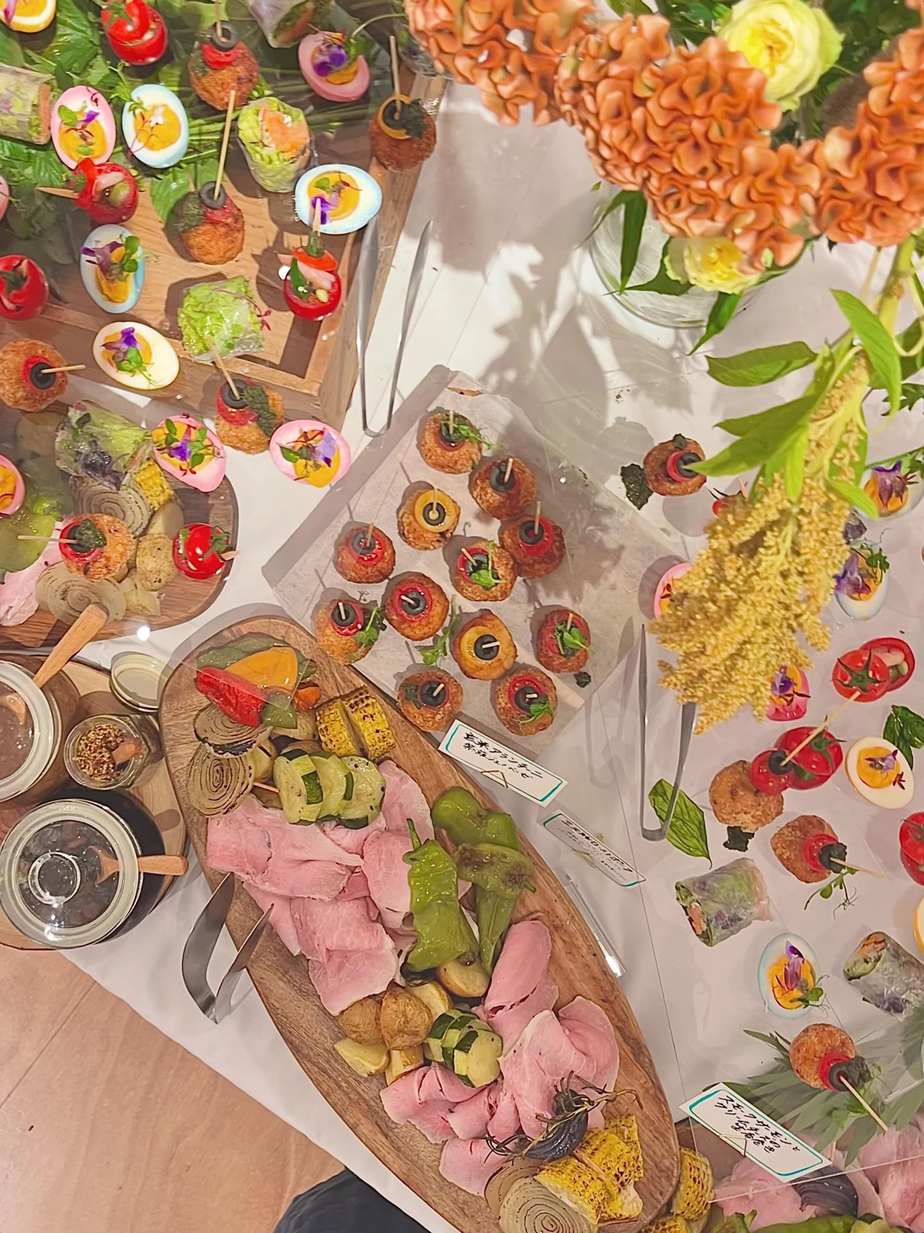 Colourful small dishes arranged with flowers and greenery for an event